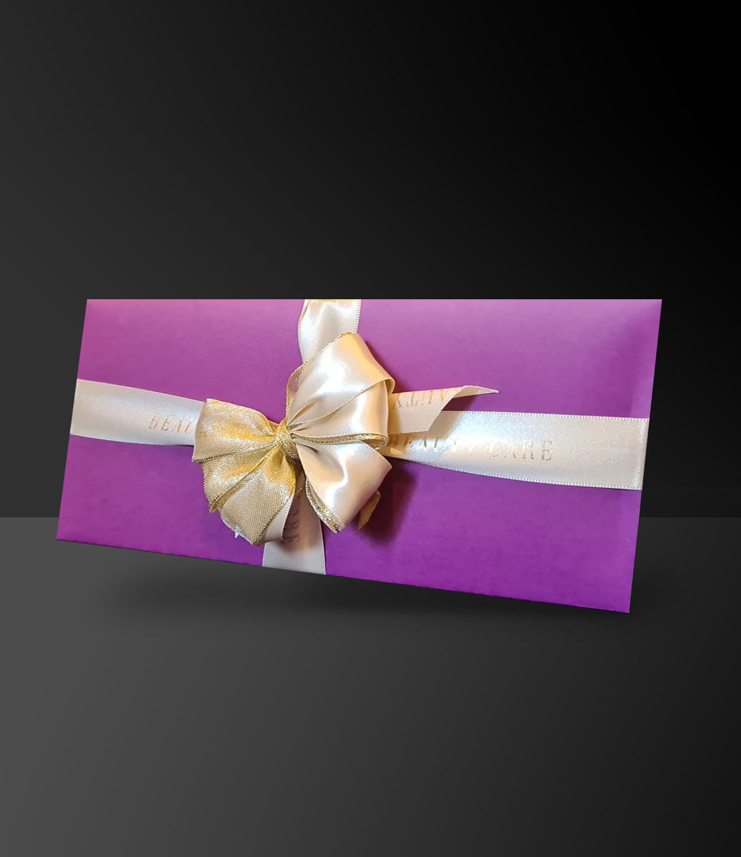 Beautycare Geschenkgutschein in einem hochwertigen lila Umschlag mit goldener Schleife.